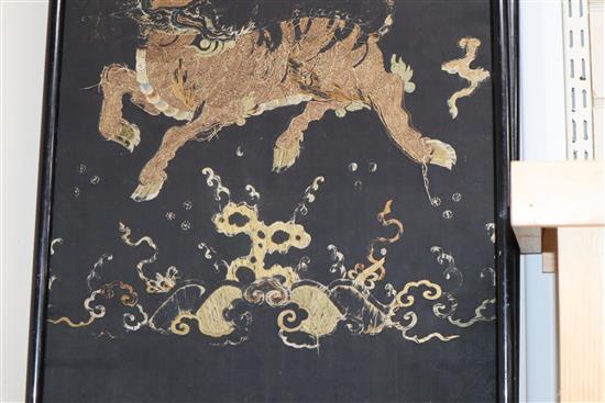 A pair of Chinese/Tibetan embroidered black satin qilin panels, late 19th/early 20th century, 144 x 44cm, worn